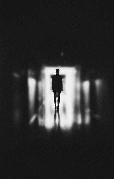 monochrome-photo-of-person-standing-on-hallway-3343253