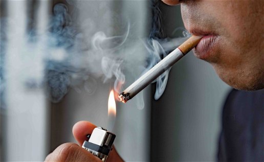 Image of a person lighting a cigarette.