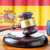 Image of a judge's gavel with flag of Spain.