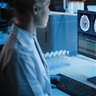 Image of Female Scientist Working on Computer Showing MRI Brain Scans.
