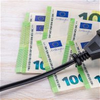 Image of electric plug lying on €100 notes.