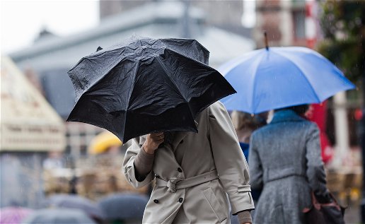 Image of people walking on the street during rainfall.