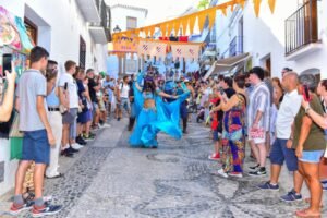 Dancer in blue costume in narrow mountain street