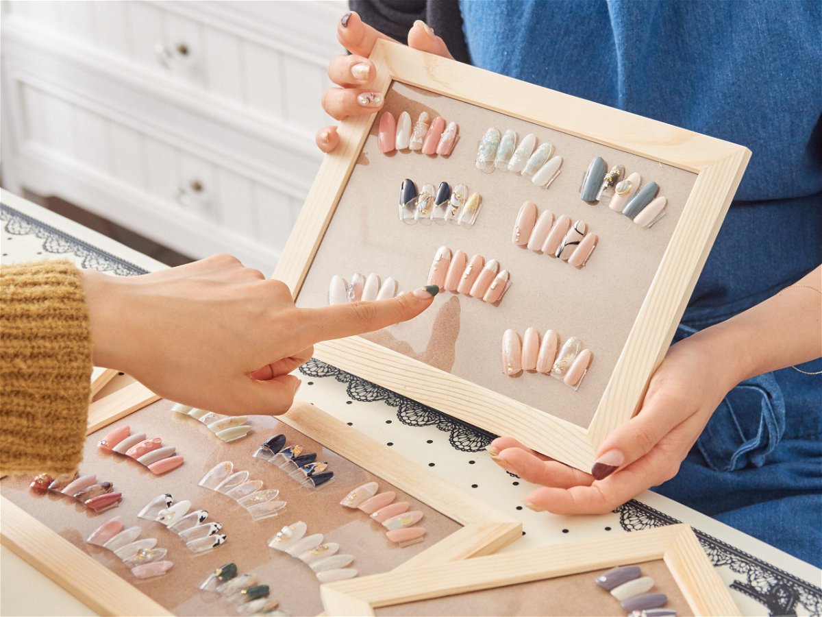 Finger pointing at different nail designs from a selection