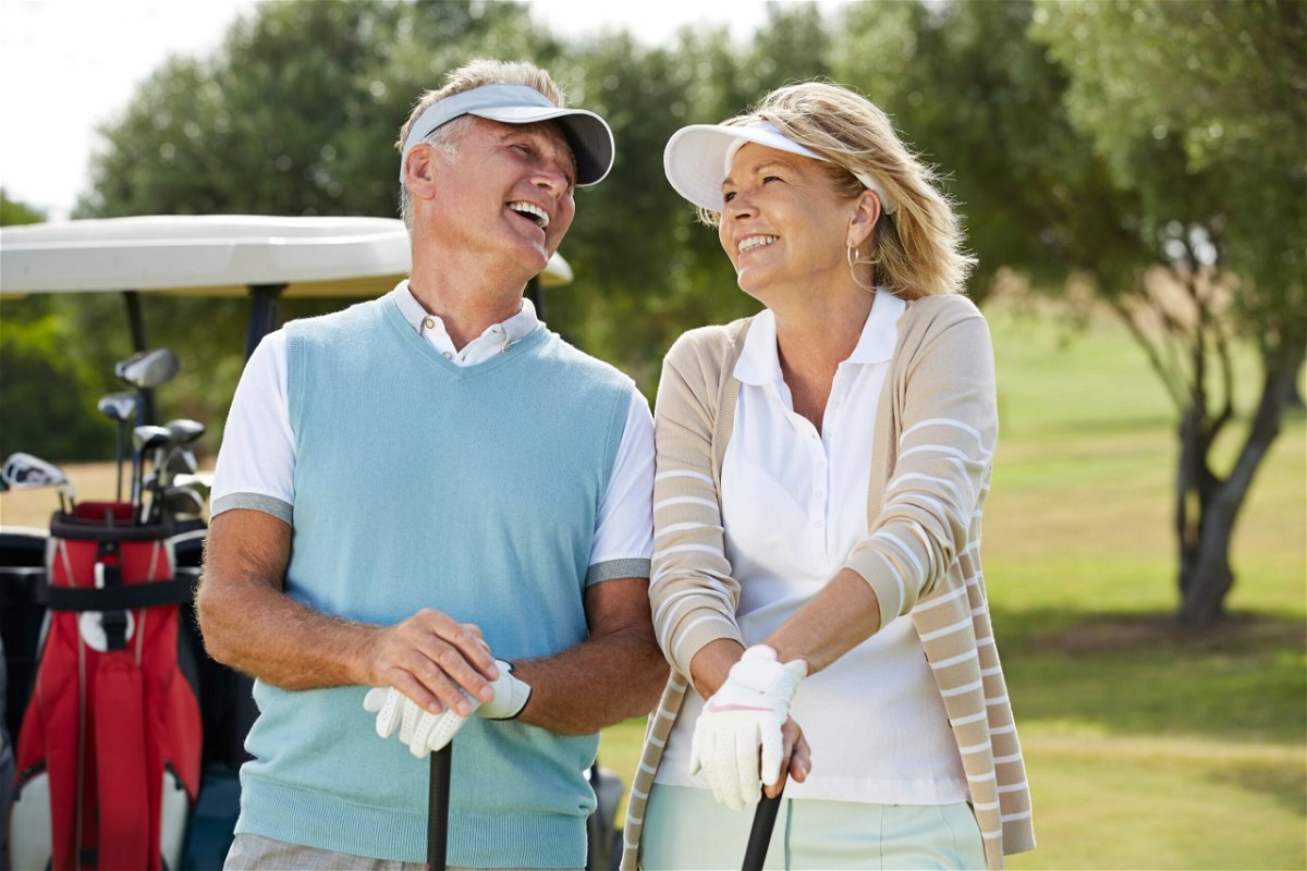 A laughing senior couple playing golf