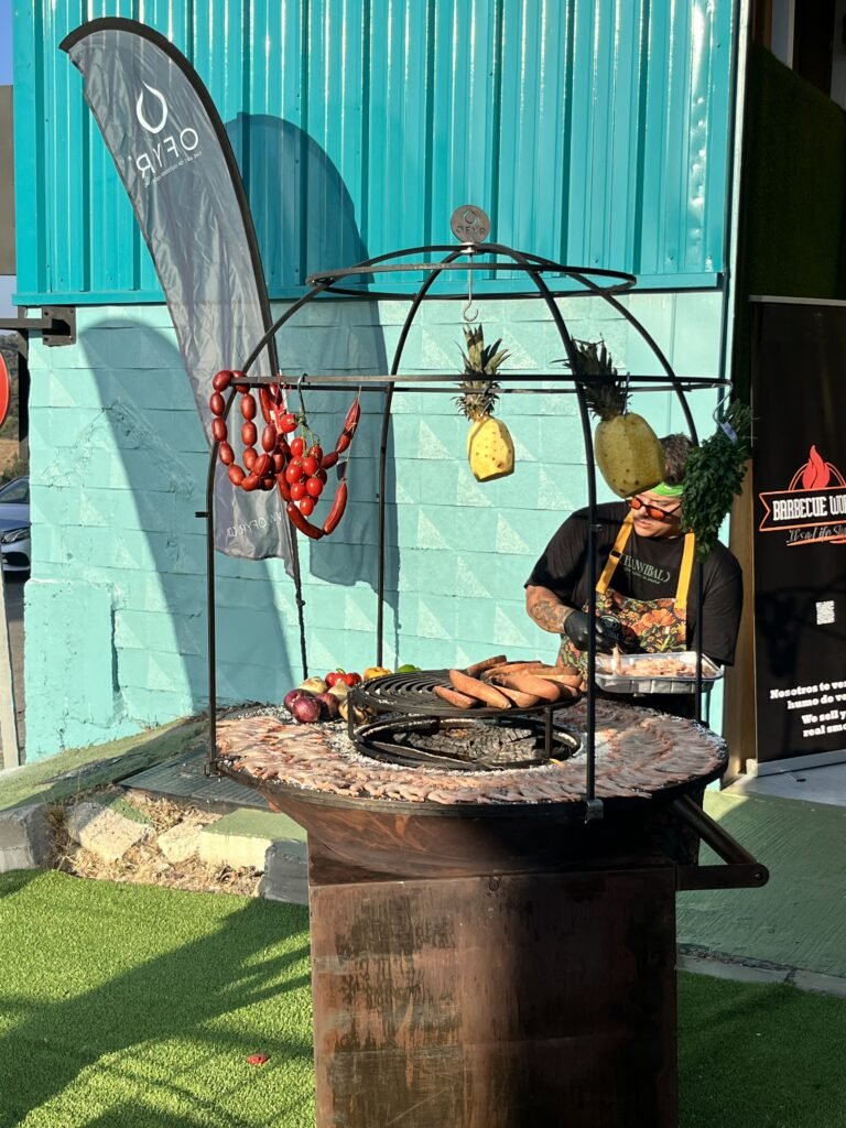 view of a premium barbecue with meat and pineapple hanging over the grill for flavour