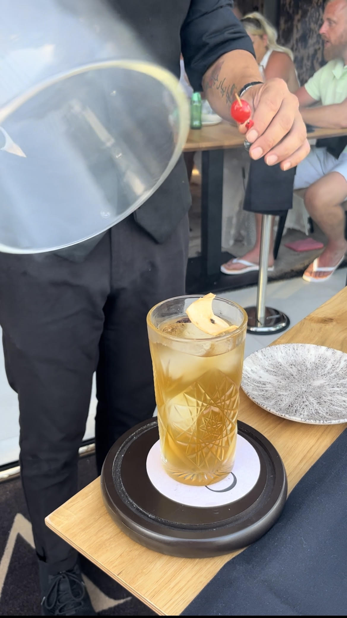 Se presenta un cóctel de manzana con una cereza glaciar y una tapa de cristal.