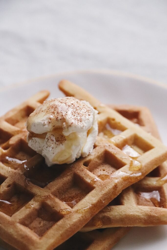 A pile of famous Belgian waffles with vanilla ice cream and sauce