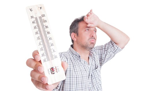 Image of a sweating man holding a thermometer.