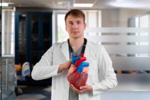 medical student holding model of heart