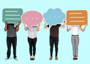 four people standing holding speech bubbles in front of their faces