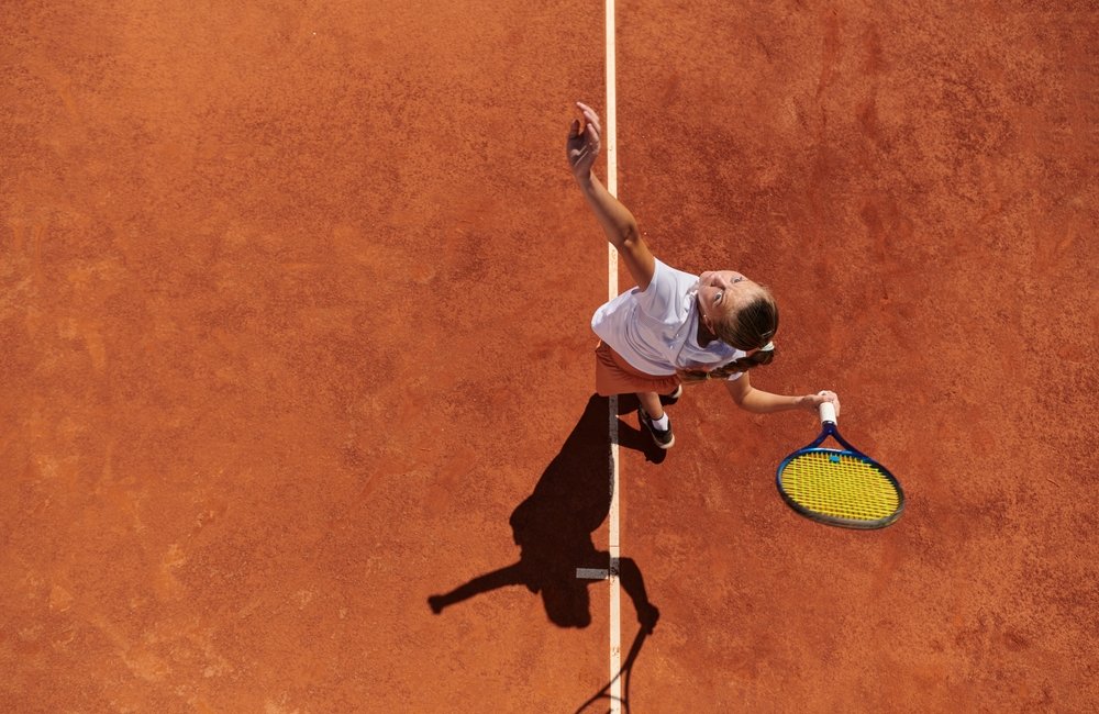 Overview shot of a female tennis player on a clay court 