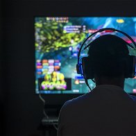 Silhouette pic of the back of a person in front of a screen gaming
