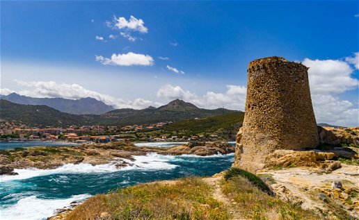 Landscape in Corsica with stone tower, town and seahore