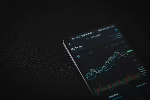 Dark black background showing a mobile phone with a screen showing a graph