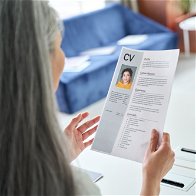 Female person holding a CV conducting an interview