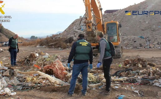 A member of the Guardia Civil talks to another man at a landfill site with a digger in the background. Euro Weekly News