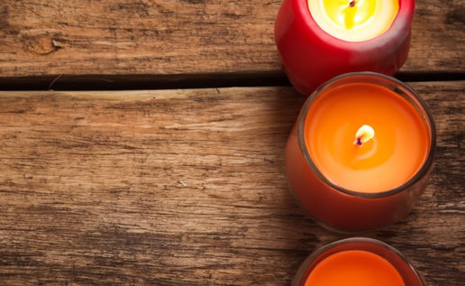 Three candles sitting on top of a wooden table next to each other. Credit: Shutterstock, Natalja Petuhova