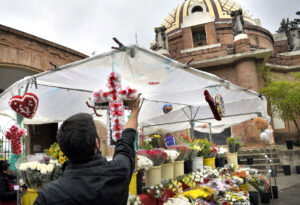 A man setting up floral offerings.
