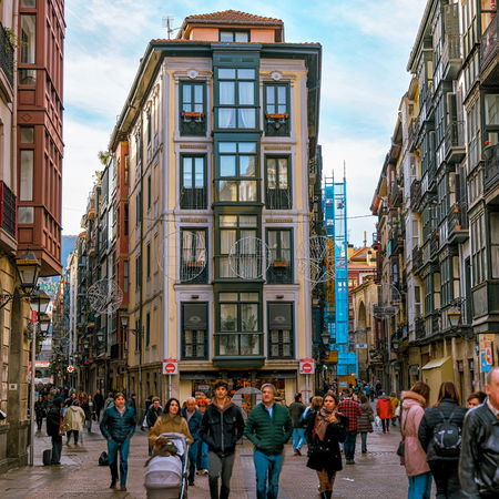 Pedestrians walking through a lively street in Bilbao city centre, northern Spain.